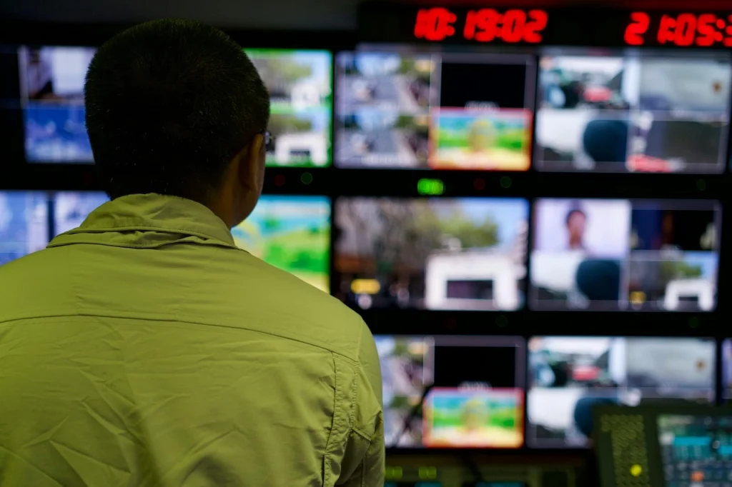 Security personnel monitoring multiple CCTV feeds in a control room for real-time surveillance operations.