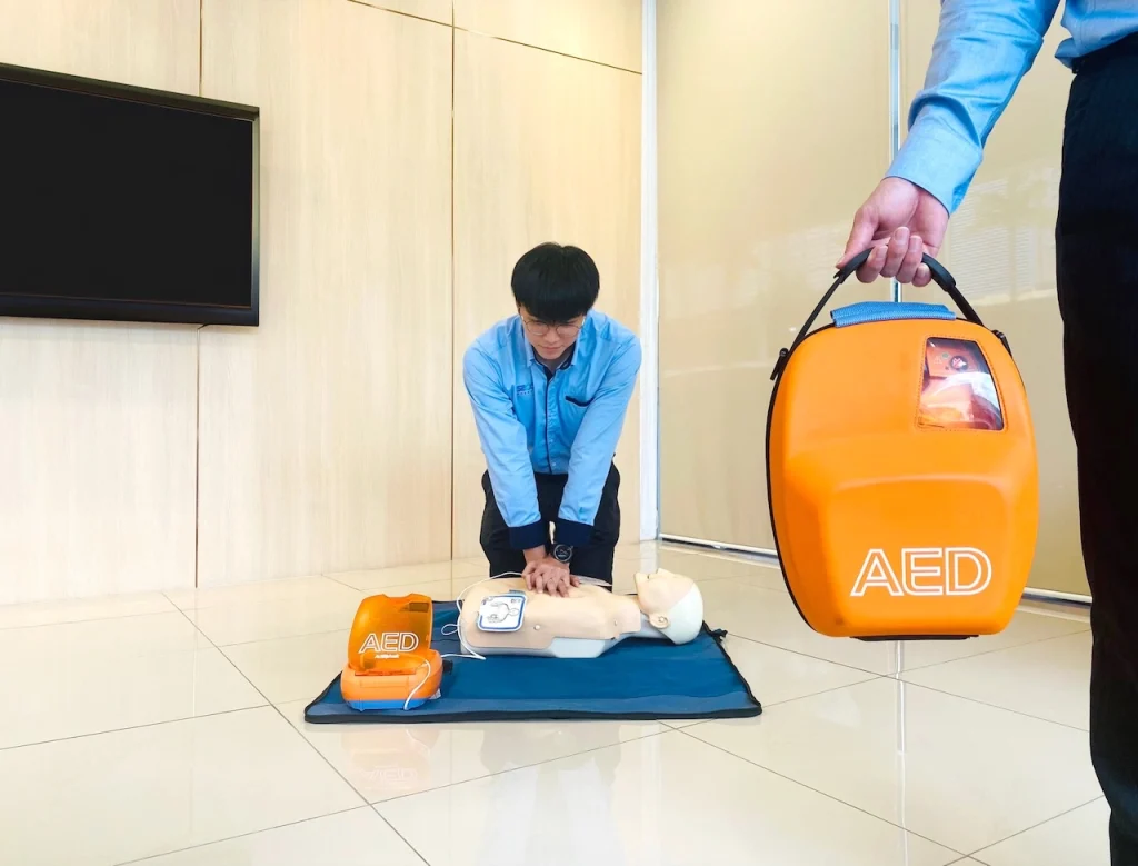 AED training demonstration with CPR manikin and automated external defibrillator in a Malaysian workplace