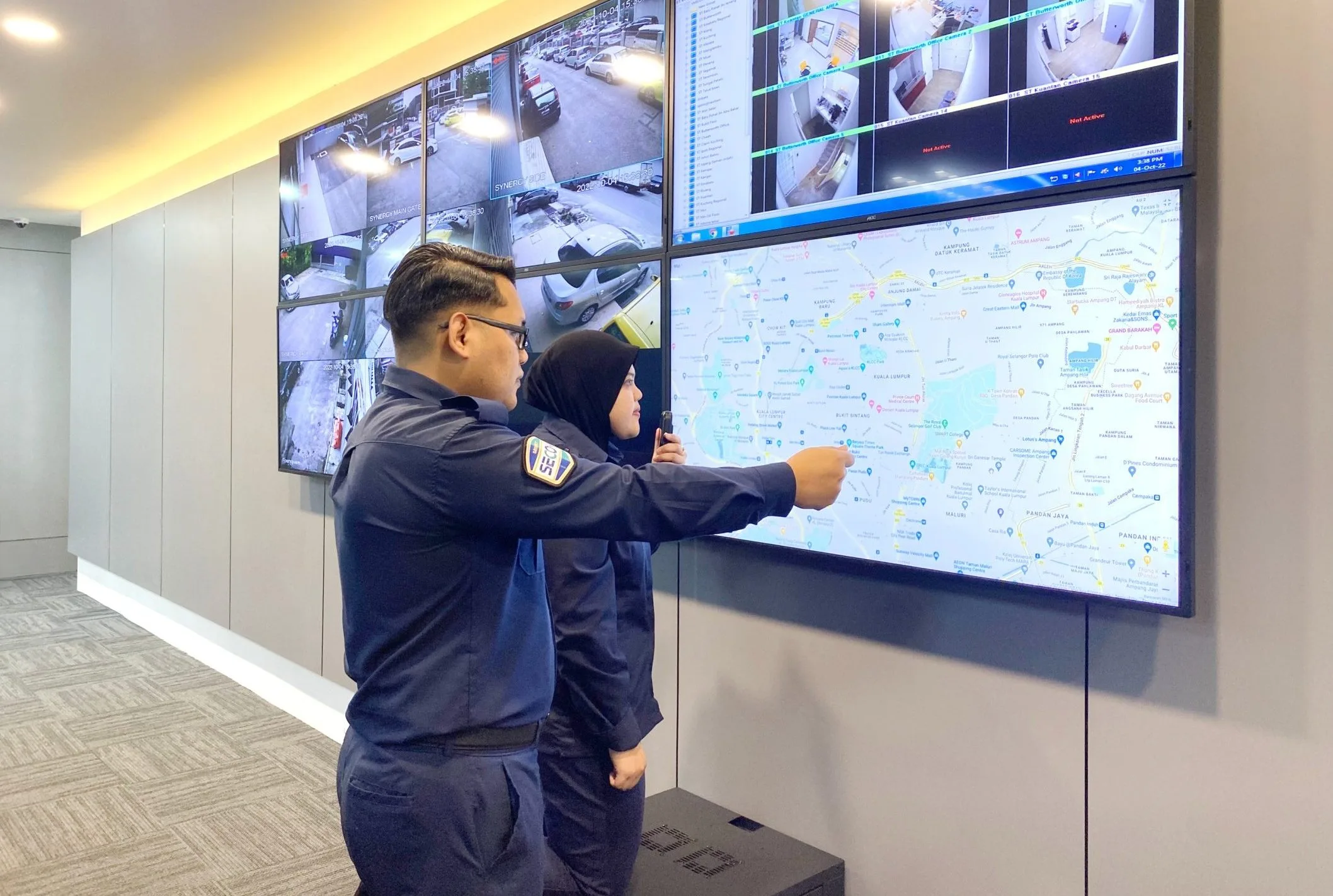 secom-malaysia-control-centre-remote-cctv-monitoring SECOM Malaysia officers viewing live CCTV feeds and a location map at the Control Centre