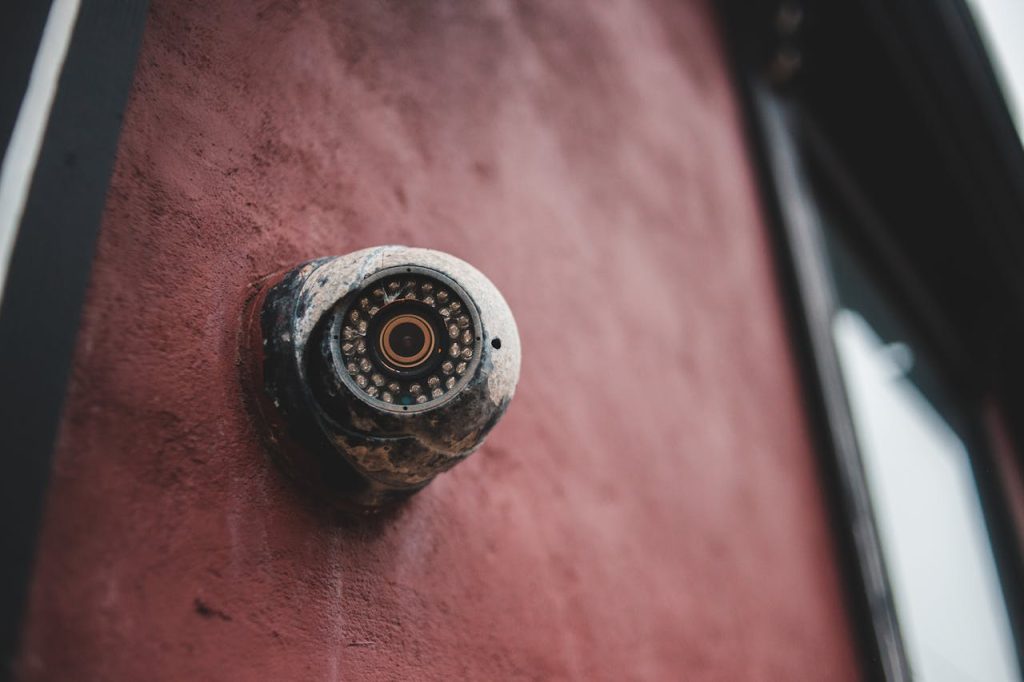 Close-up of a CCTV security camera integrated with central monitoring system software for real-time surveillance.