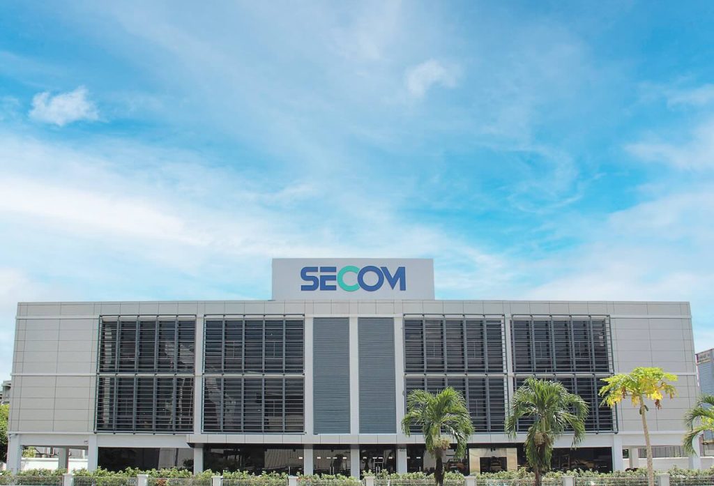 Modern SECOM Malaysia headquarters building exterior under blue sky, symbolising reliable outsourced security services in Malaysia.