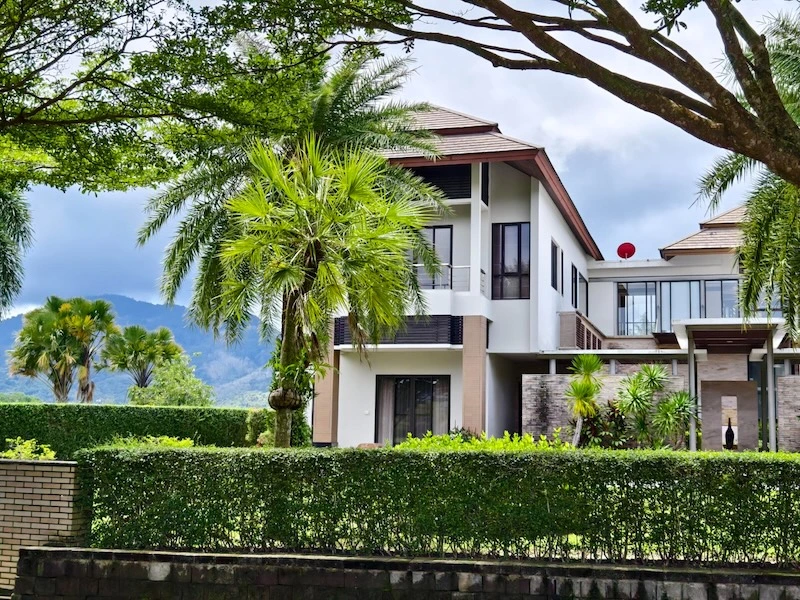 vacant-home-security-holidays-malaysia Modern two-storey home behind a garden hedge, protected while the family is away on holiday